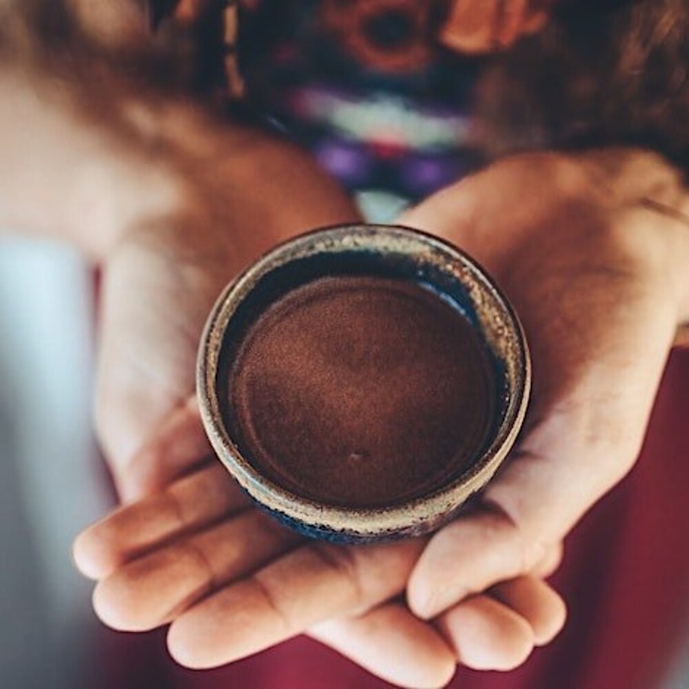 Ceremonial cacao held in two hands