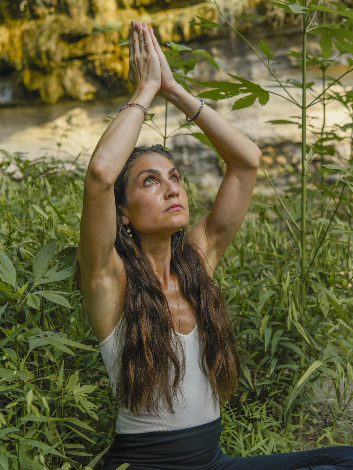 Pritam Tara practicing yoga beside a waterfall